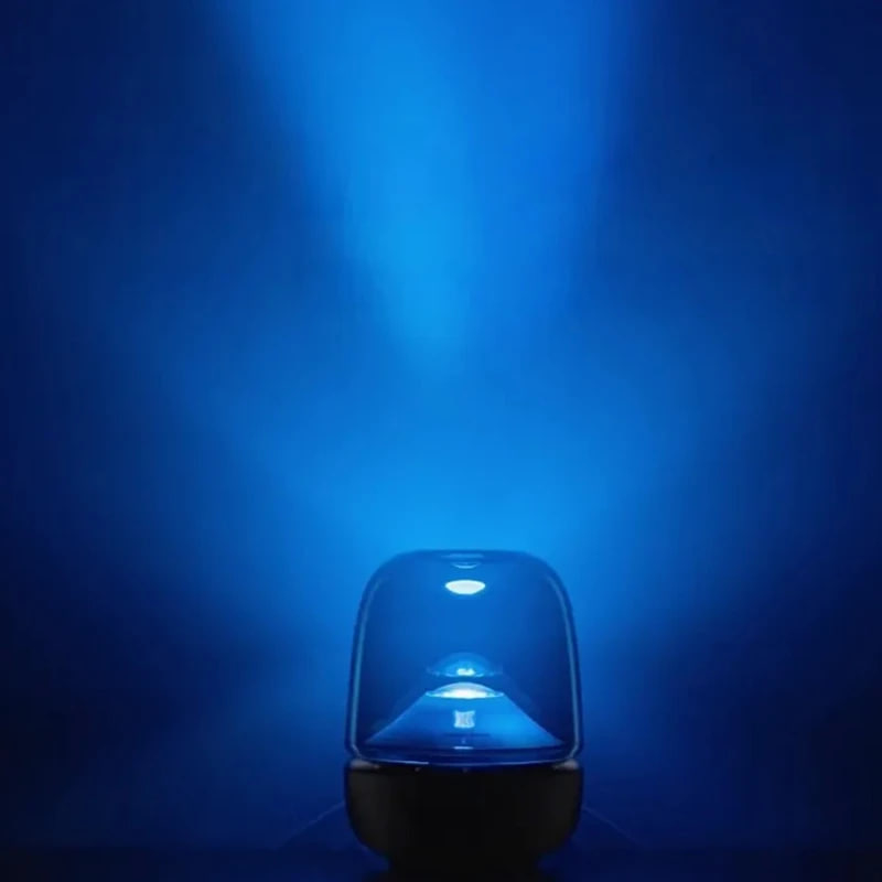 اسپیکر بلوتوثی هارمن کاردن مدل Aura Studio 5 با رقص نور آبی و انعکاس روی دیوار